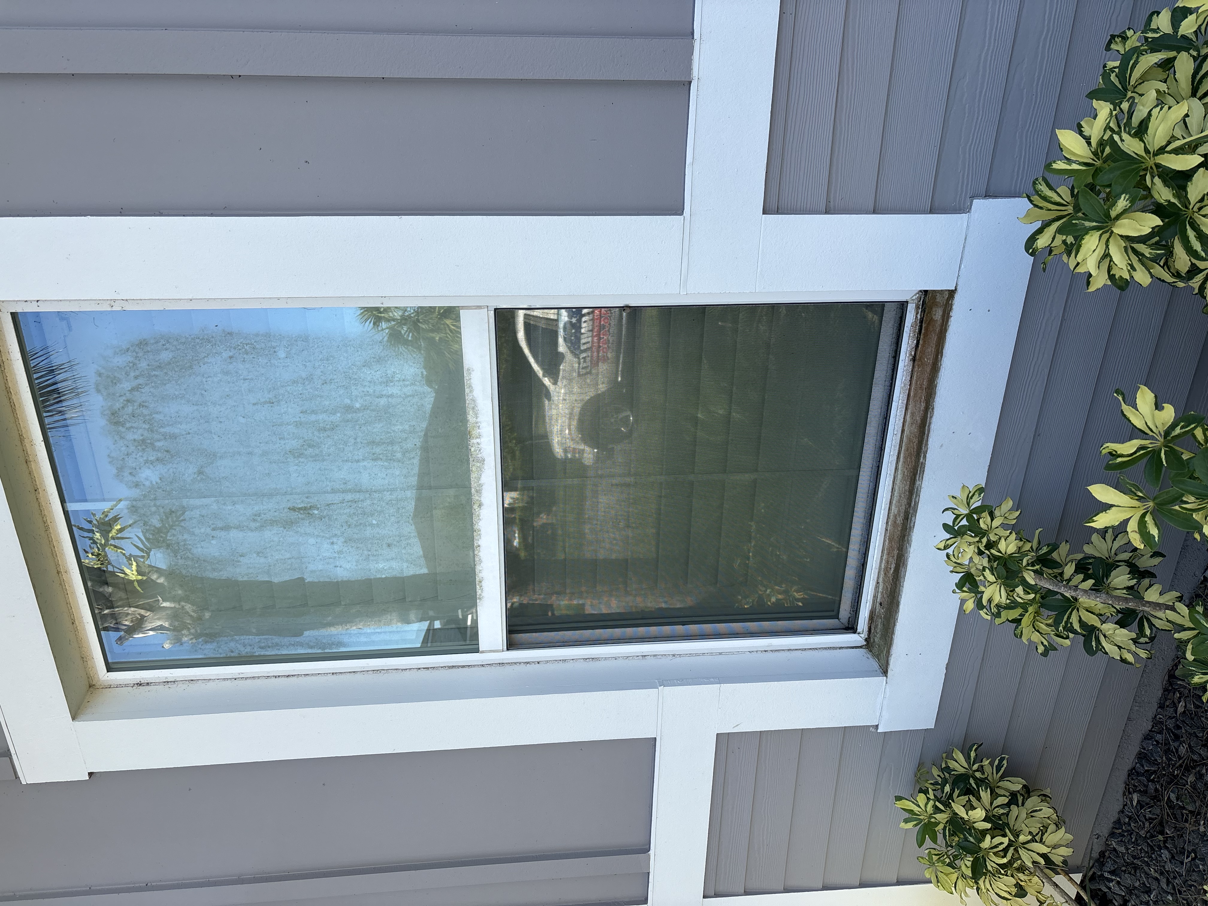 Exterior window with buildup on the glass and frame before cleaning